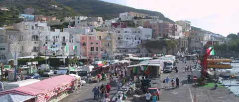 Il porto di Ponza con le case color pastello del borgo affacciate sulla banchina e le barche ormeggiate