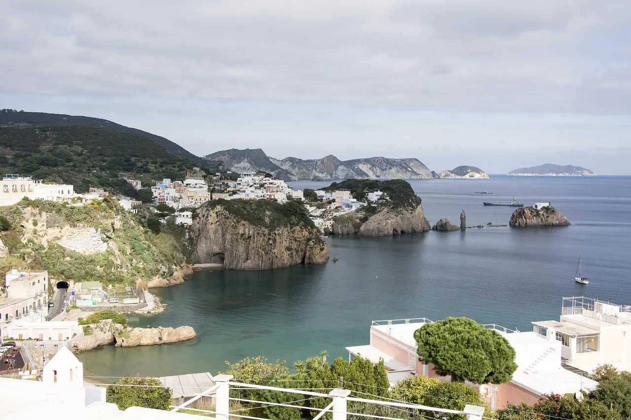 Veduta dall'alto della costa rocciosa di Ponza con il mare aperto e le altre isole pontine sullo sfondo
