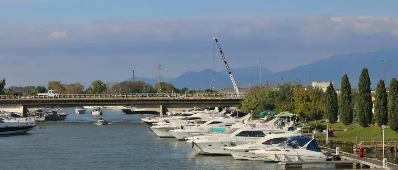 Yacht e barche ormeggiate nel Porto Canale di Terracina, con il ponte e le colline sullo sfondo