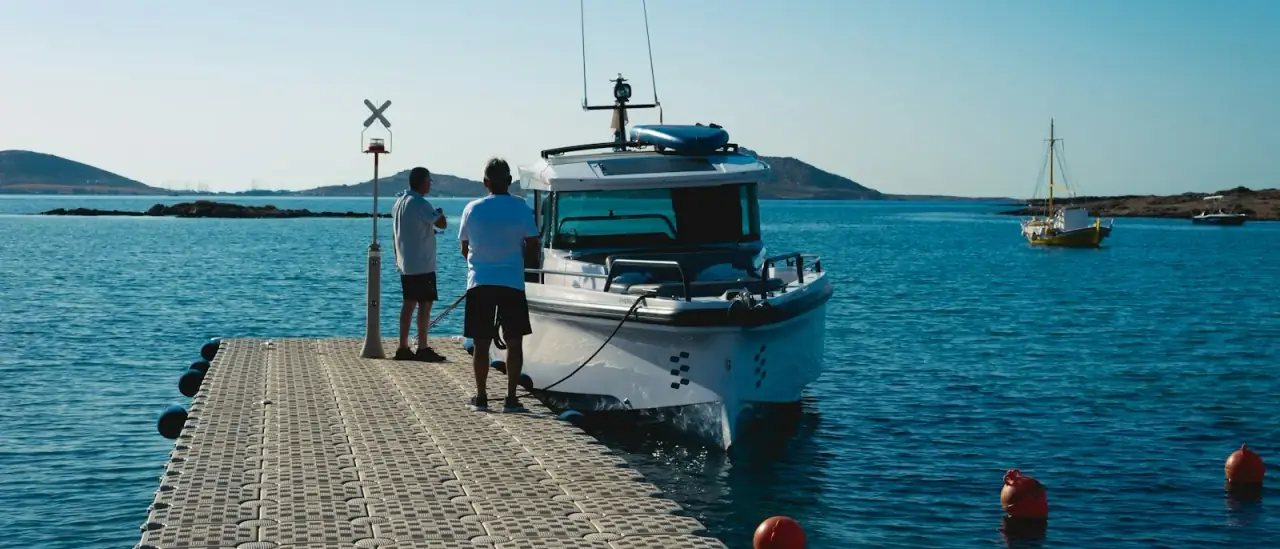 Due uomini su un pontile accanto a una barca ormeggiata