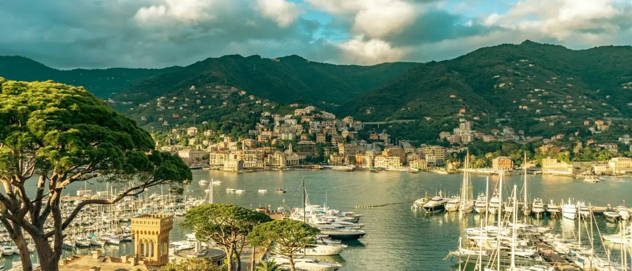Il porto di Rapallo pieno di barche, con le colline della riviera ligure sullo sfondo
