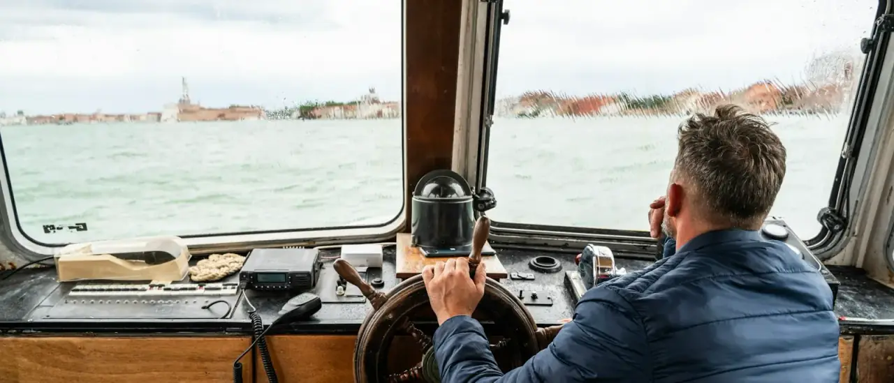 Persona al timone di un motoscafo in navigazione sul mare