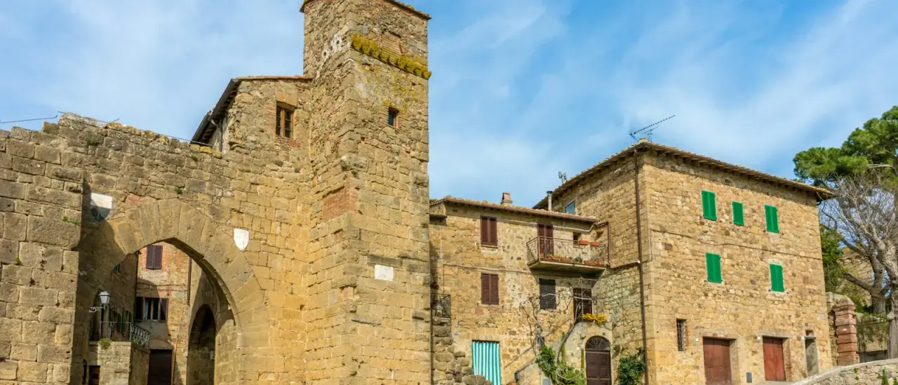 Arco d'ingresso in pietra e torre di un borgo medievale italiano