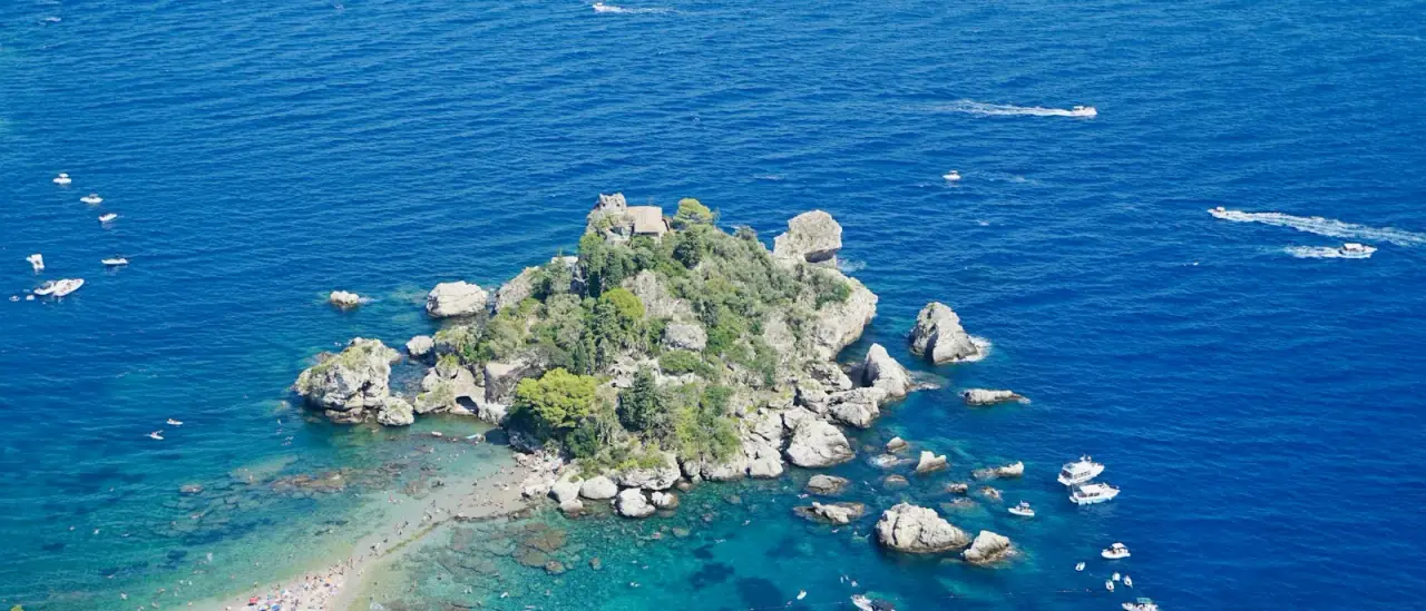 Isola Bella di Taormina vista dal mare, con la costa rocciosa e le acque turchesi della Sicilia ionica