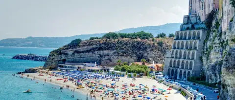 Una cala turchese della costa di Tropea con alcune barche all'ancora