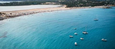 Barche ormeggiate sull'acqua turchese di una spiaggia di Villasimius, in Sardegna