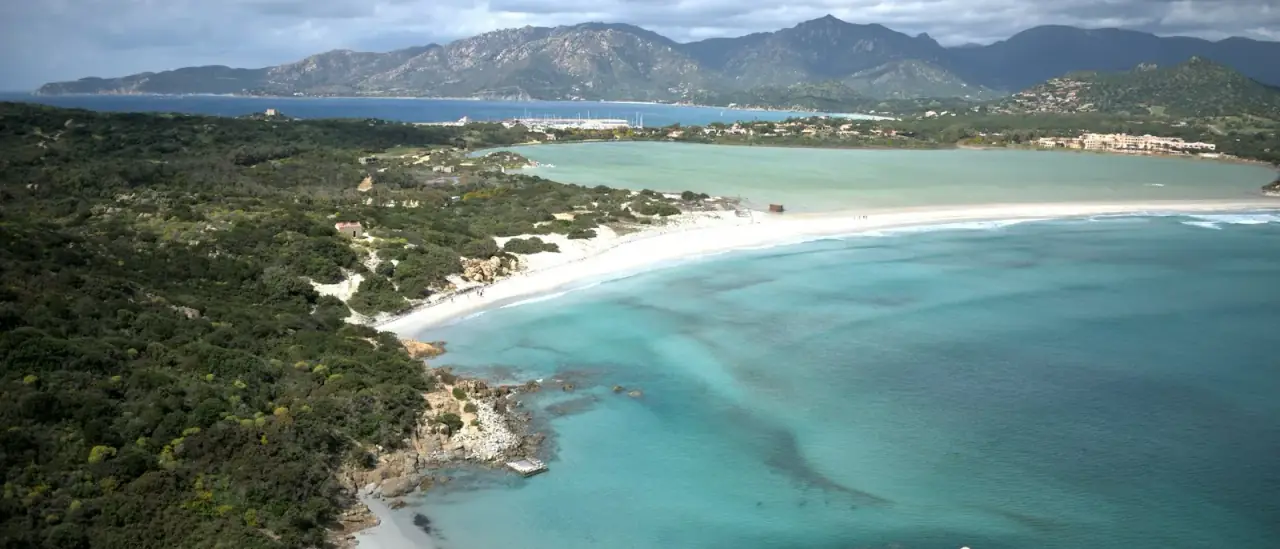 Veduta aerea della spiaggia e della laguna di Capo Carbonara a Villasimius, con piccole barche sulle acque turchesi