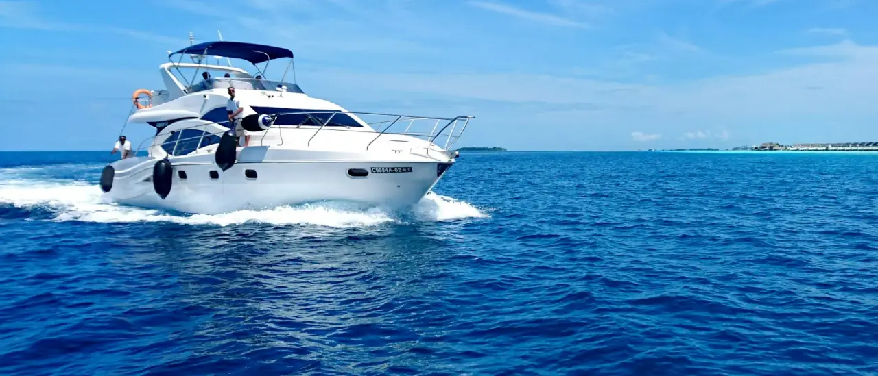 Yacht a motore bianco e blu in navigazione su mare aperto sotto un cielo sereno